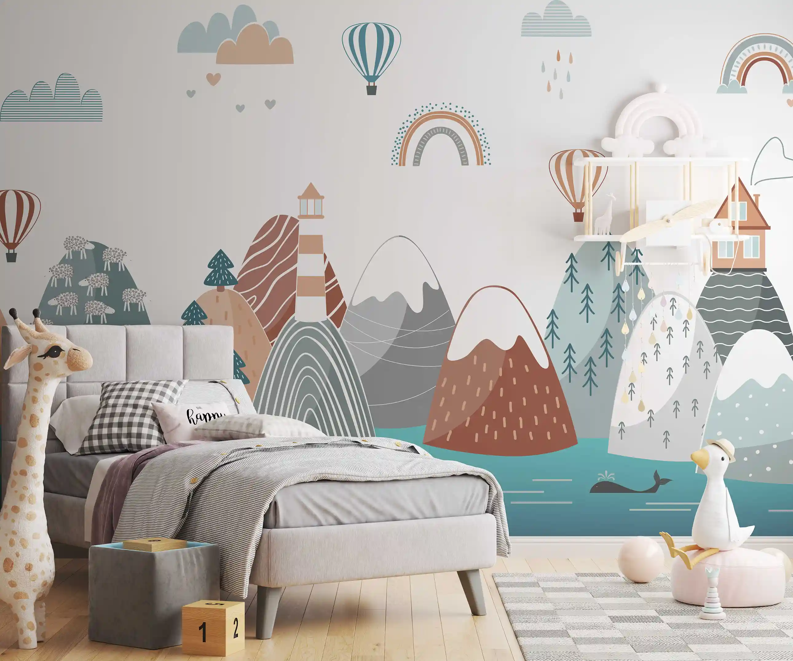 Bunte Berglandschaft Tapete im Kinderzimmer mit grauem Polsterbett, Stoffgiraffe und Holzwürfeln