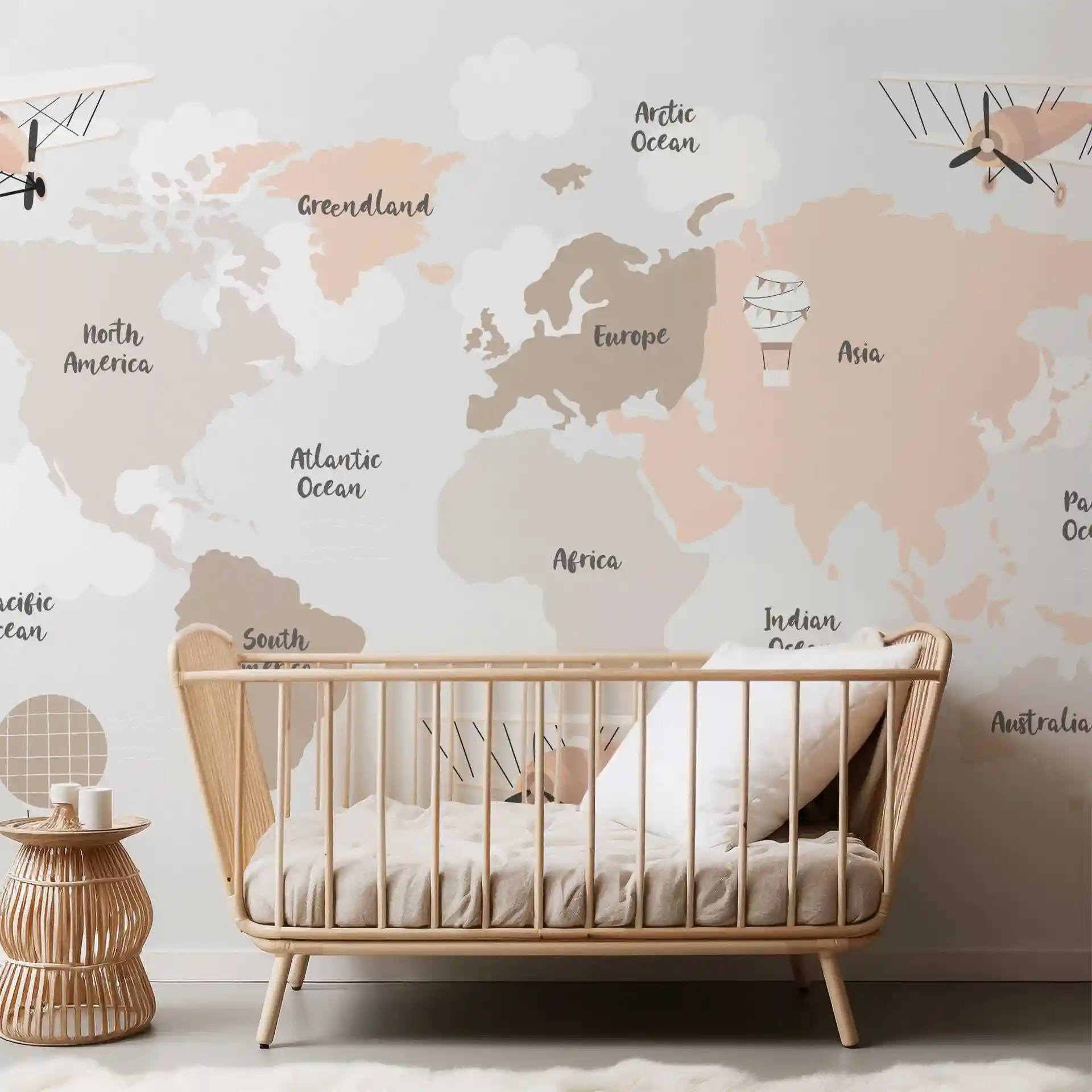 Weltkarte Tapete Beige mit Flugzeugen hinter einem Babybett aus Holz und einem Rattan-Beistelltisch