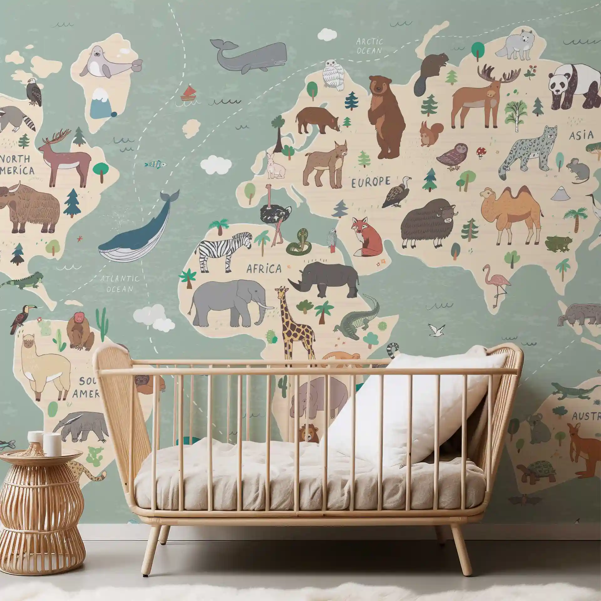 Tapete Weltkarte Tiere in Grün und Beige hinter einem Babybett aus Rattan mit Beistelltisch aus Rattan