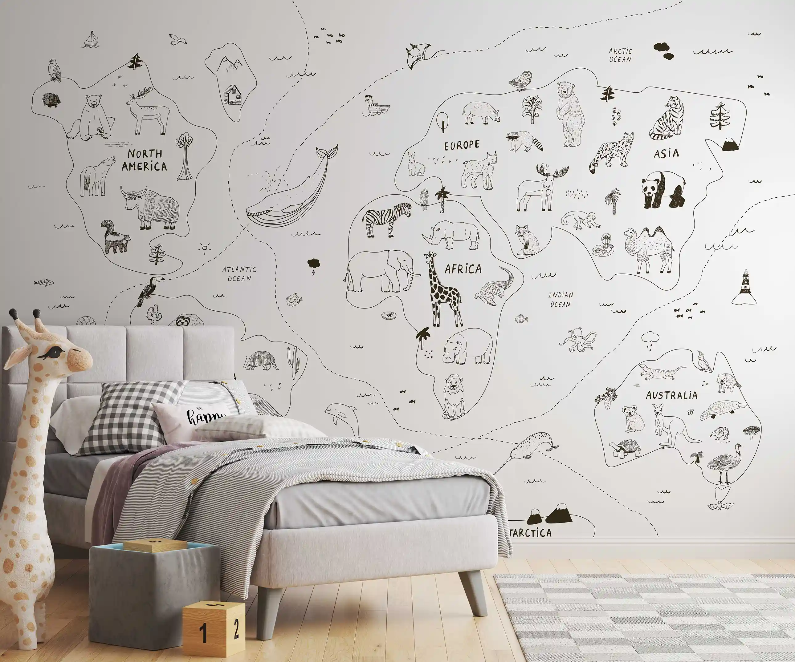 Tapete Weltkarte minimalistisch mit Tierzeichnungen, davor graues Polsterbett, Giraffenfigur und Holzwürfel