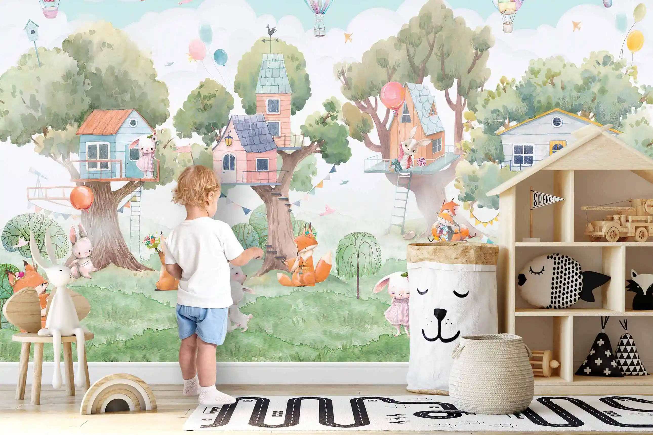 Baumhaus Hasen Tapete im Kinderzimmer mit Kind vor der Wand, Hausregal, Aufbewahrungskorb und Spielteppich