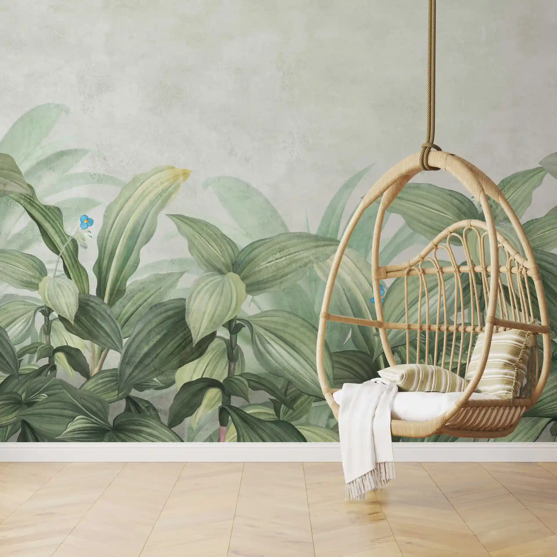 Tapete Pflanzen Grün mit großen Blättern hinter einem Hängesessel aus Rattan mit Kissen und Decke
