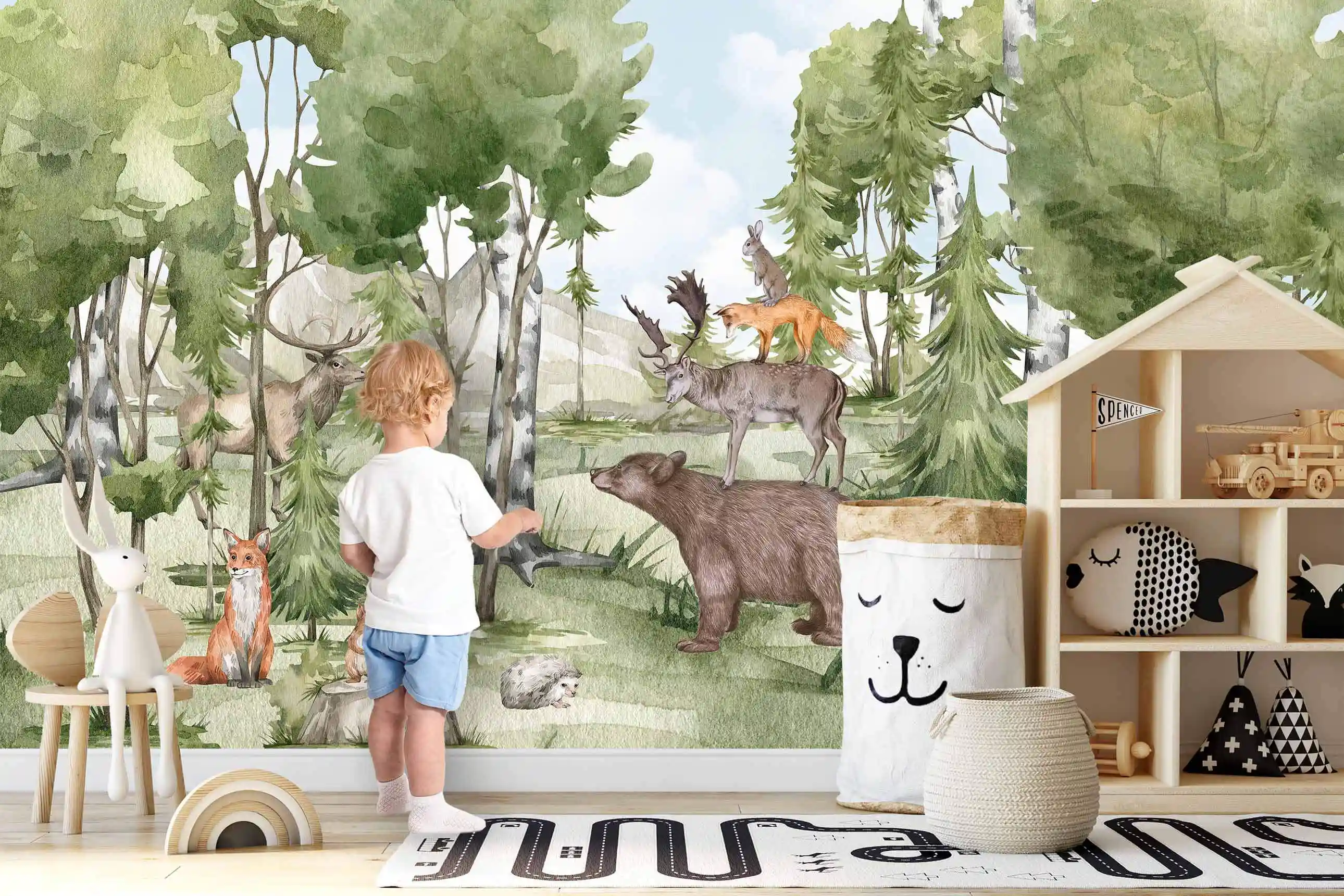 Wald Tiere Tapete mit Bär und Elch, davor ein Kind an der Wand neben Hausregal und Aufbewahrungskorb