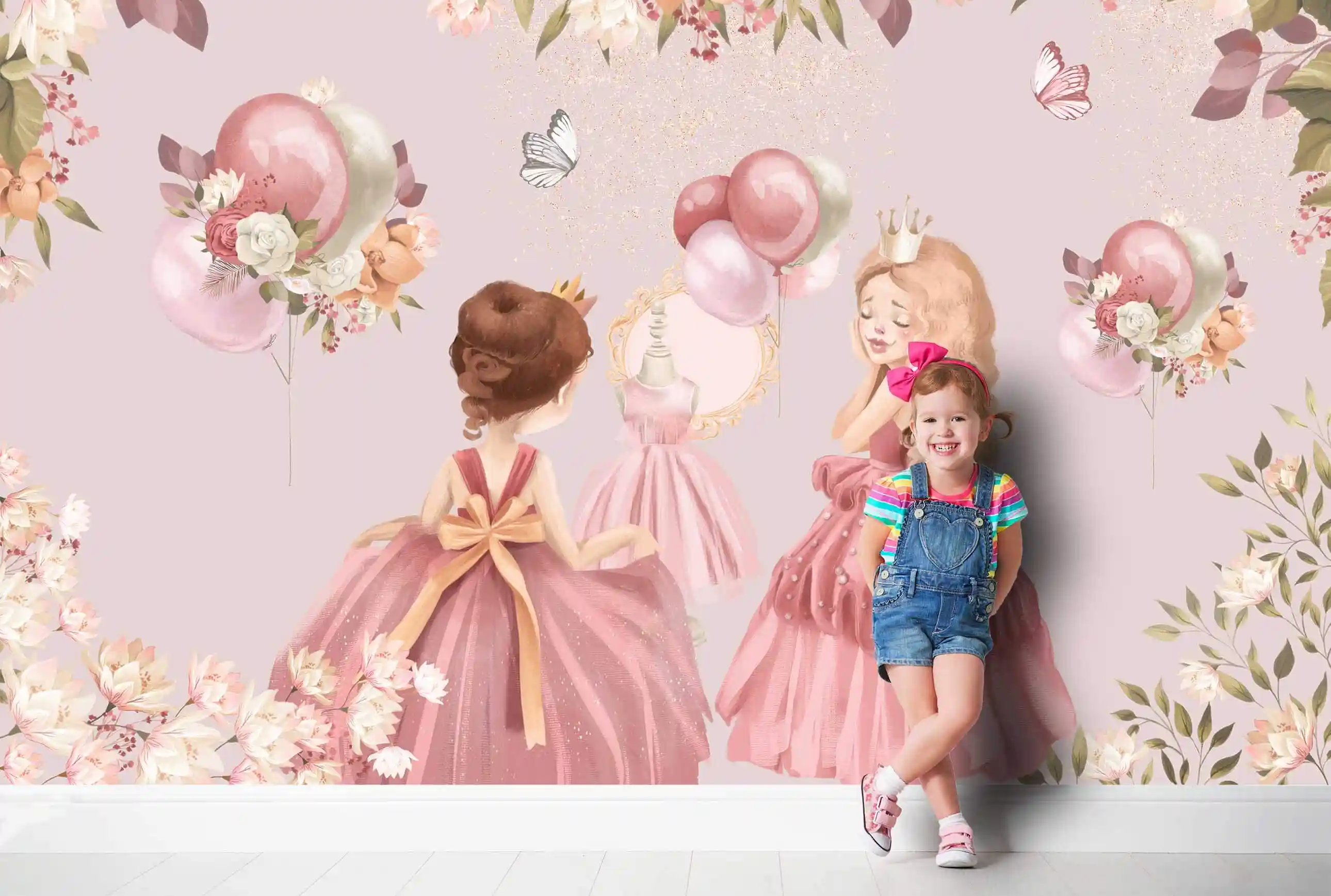 Prinzessin Tapete mit Luftballons und Blumen, davor lehnt ein Mädchen mit pinker Haarschleife und Latzhose an der Wand